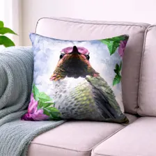 Hummingbird pillow featuring a hummingbird surrounded by green leaves and pink flowers.